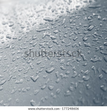 drops of water on silver metal texture gray background small depth of field oblique line of light on the top of image
