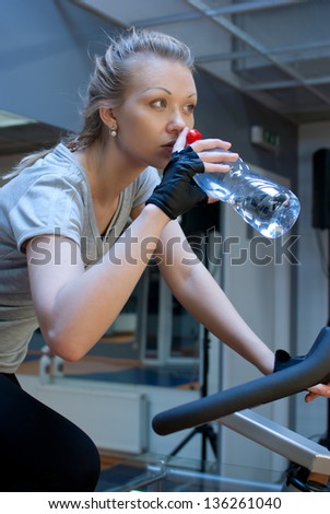 Woman in fitness club drink water