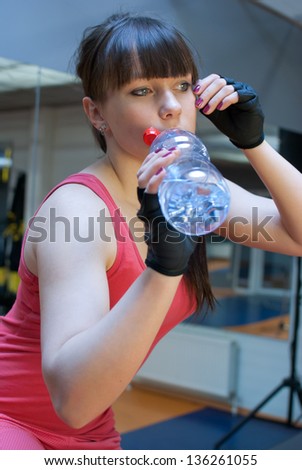 Woman in fitness club drink water