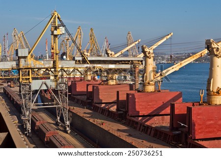 Ukraine, Odessa - AUGUST 2, 2014:Grain from silos being loaded onto cargo ship on conveyor belt with freight train