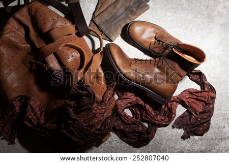 Brown leather bag and accessories on a dark background