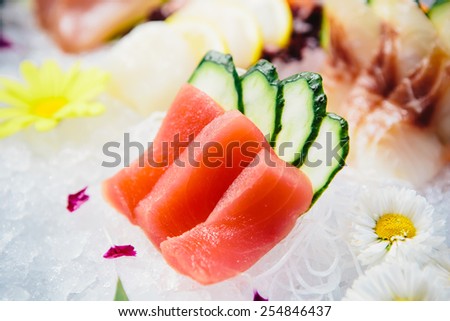 Tuna Sashimi - Maguro fresh raw tuna on Daikon White Radish. Garnished with Ginger, Wasabi, Seaweed, Cucumber, Salad Leaf and Lemon