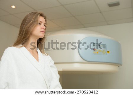 Happy woman undergoing open Magnetic resonance imaging scan.