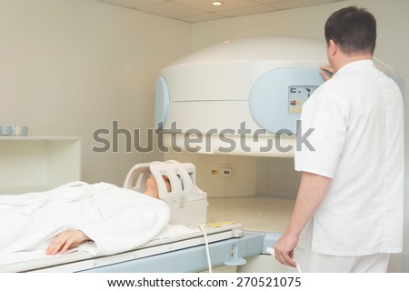doctor examining woman at Magnetic resonance imaging