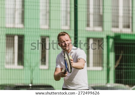 young man play tennis outdoor on tennis field at early morning
