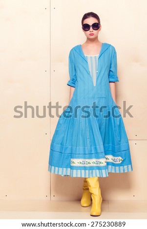 Full-length portrait of a lovely woman in romantic dress on wodden background