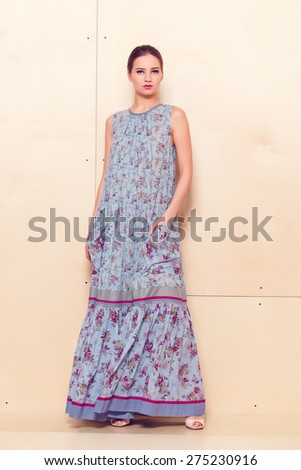 Full-length portrait of a lovely woman in romantic dress on wodden background