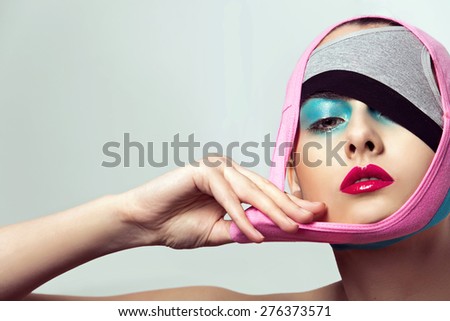 closeup portrait of beautiful young woman with creative makeup and hairstyle
