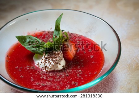strawberry soup with ice cream and mint on a plate decorated fresh strawberries and chocolate