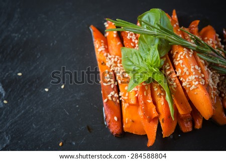 Caramelized carrots on black table. Shallow DOF