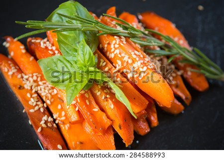 Caramelized carrots on black table. Shallow DOF
