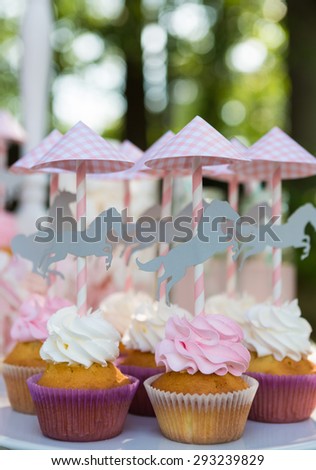 Dessert table for a party. Cake, cupcakes, sweetness and flowers. Shallow dof