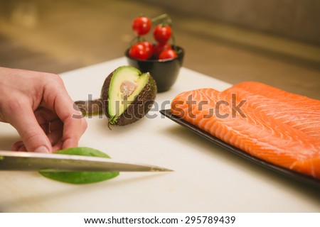 Cutting the salmon with a knife,Japanese chef making sashimi in kitchen,Sushi are made