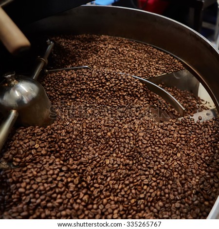 Freshly roasted coffee beans in a coffee roaster. Shallow dof