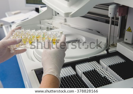Lab tech loading samples into a chemistry analyzer