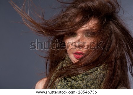 Woman with fluttering hair. On dark background.