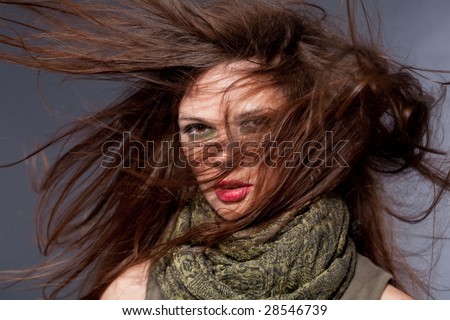 Woman with fluttering hair. On dark background.