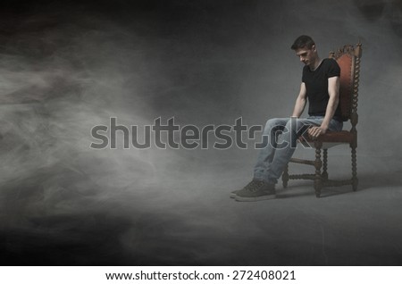 man sitting and think on a chair, cloudy room