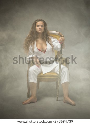 sexy judo girl sitting on sofa, cloudy room