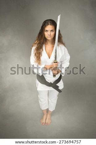 karate performer with sword on hand, cloudy room