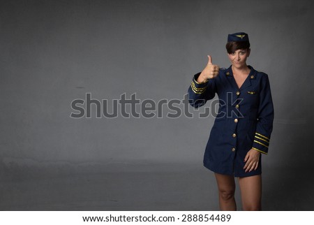 air hostess thumbing up, dark background