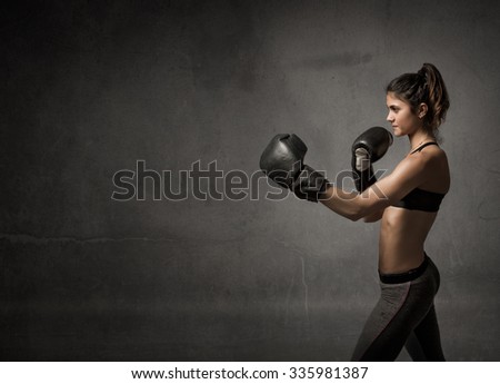 female boxer ready fot attack, dark background