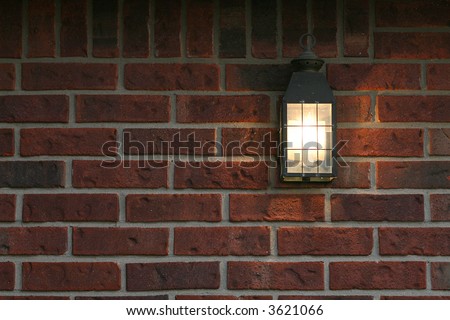 welcoming porch light on brick wall