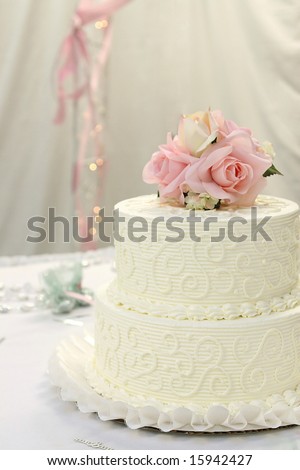 Traditional wedding cake with pink and cream rose cake topper.