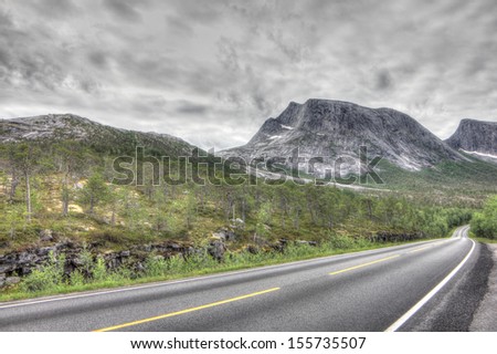 Norwegian landscape with road in tundra and mountains