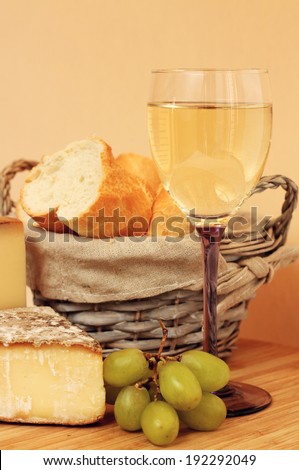 Composition with french wine, cheese and grape on wooden table