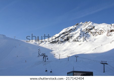 Ski lift chairs on bright winter day in Alp mountains