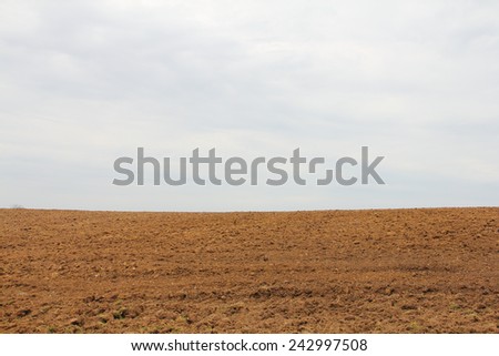 Dry plowed earth agricultural land hill and sky background