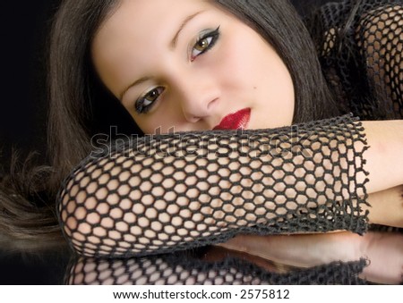 woman with dark hair and red lips wearing a black net-shirt