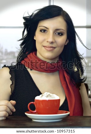 a girl is drinking coffee in a cafeteria