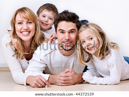 sweet young family having fun on the floor in their home