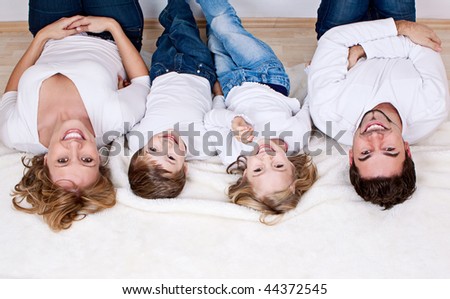 sweet young family having fun on the floor in their home