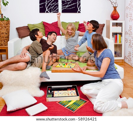 a young family is playing board-games in their bed
