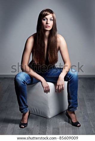 beautiful girl with long, attractive hair sitting on a stool
