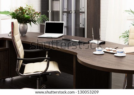 laptop and flowers on the table in a modern office