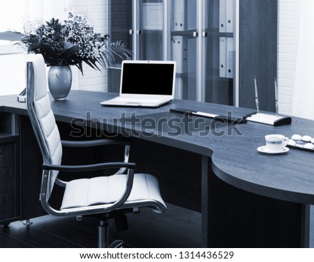 laptop and flowers on the table in office