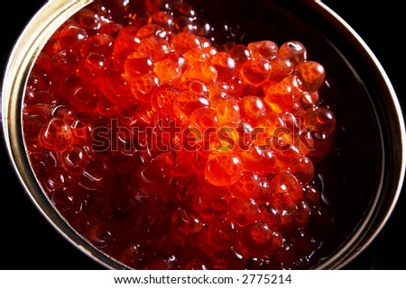 Red caviar in a can on a black background