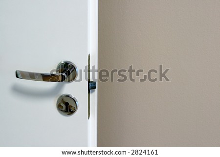 White door with the lock on a background of a wall