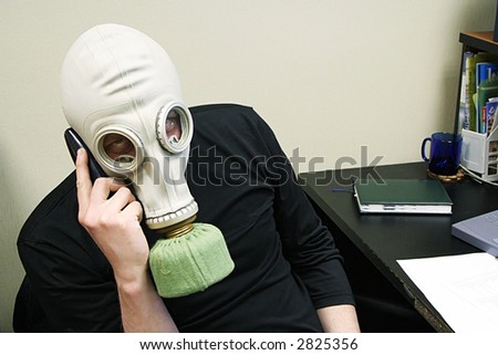 The person in a gas mask speaks by phone