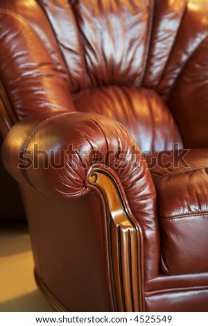 Beautiful red leather armchair with a pillow