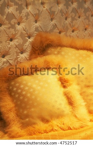 Two yellow silk pillows on a bed