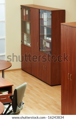 Wooden bookcase with folders at modern office