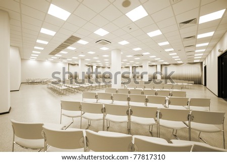 large and modern white auditorium with blue curtains