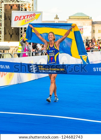 STOCKHOLM - AUG, 24: Lisa Norden crossing the finish line with a swedish flag, winner of the Women ITU World Triathlon Series event Aug 24, in Stockholm, Sweden