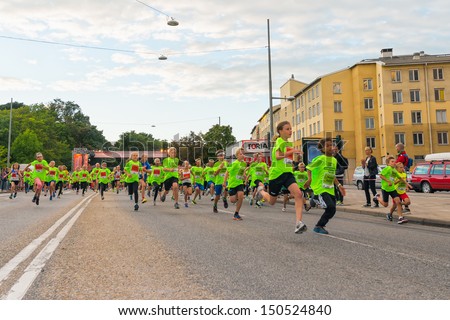 STOCKHOLM - AUG, 17: Just after the start in the Midnight Run for children (Lilla Midnattsloppet) event, a group of excited children running. Aug 17, 2013 in Stockholm, Sweden