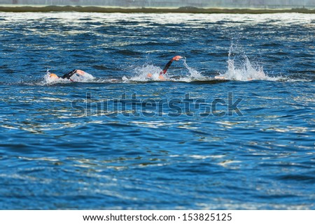 STOCKHOLM - AUG, 25: Three swimmers during the first lap in the mens swimming at the Mens ITU World Triathlon Series event Aug 25, 2013 in Stockholm, Sweden